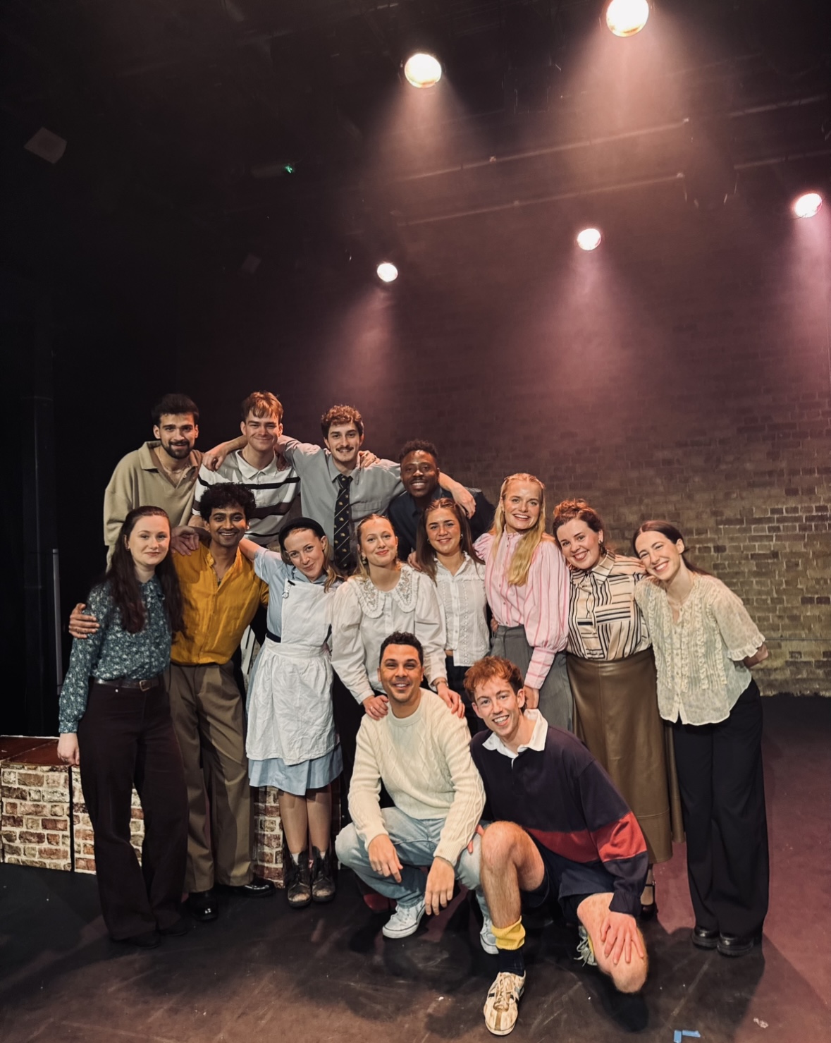 A theatre company gathered together on stage